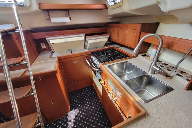 Slide: The Image of Interior of 2001 Hunter Passage 420 yacht kitchen with stove, sink, and wooden cabinetry. - 16