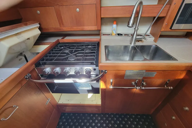 Slide: The Image of Hunter Passage 420 yacht kitchen with stove, sink, and wooden cabinetry, 2001 model. - 18