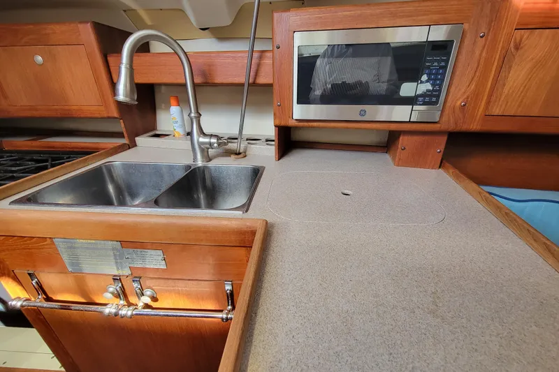 Slide: The Image of Kitchen area of 2001 Hunter Passage 420 yacht with sink and microwave. - 19