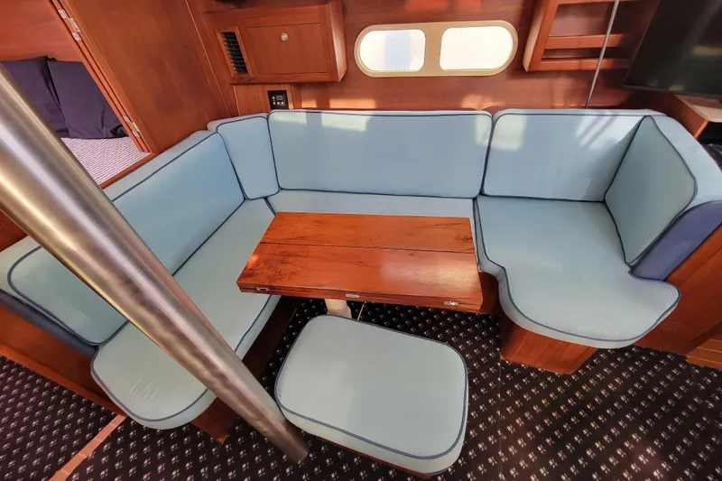 Slide: The Image of Cozy interior of 2001 Hunter Passage 420 yacht with blue seating and wooden table. - 21
