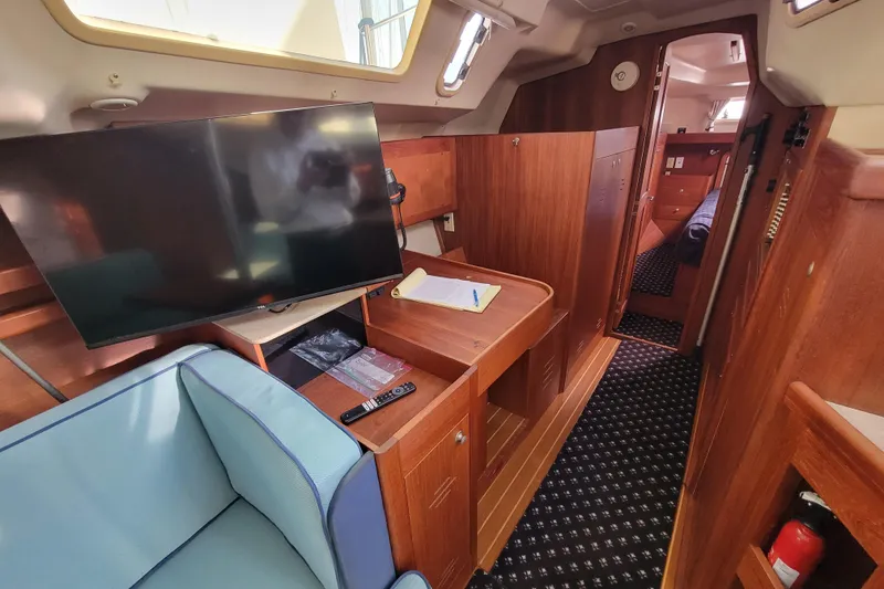 Slide: The Image of Interior of 2001 Hunter Passage 420 yacht with TV, seating, and wooden cabinetry. - 23