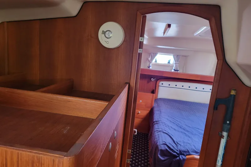 Slide: The Image of Interior of 2001 Hunter Passage 420 yacht, featuring wooden cabinetry and a cozy bedroom. - 24