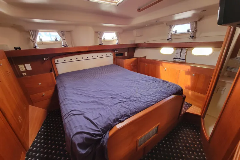 Slide: The Image of Luxurious cabin interior of 2001 Hunter Passage 420 yacht with wooden furnishings. Master centerline queen - 25