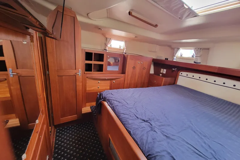 Slide: The Image of Interior of 2001 Hunter Passage 420 yacht with wooden cabinetry and cozy sleeping area. - 27