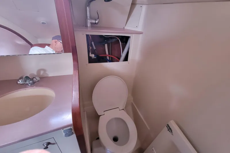 Slide: The Image of Bathroom interior of 2001 Hunter Passage 420 sailboat, featuring sink and toilet. - 28