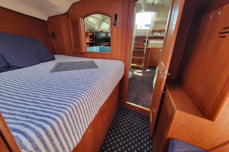 Slide: The Image of Interior of 2001 Hunter Passage 420 yacht with cozy cabin and striped bedding. - 30