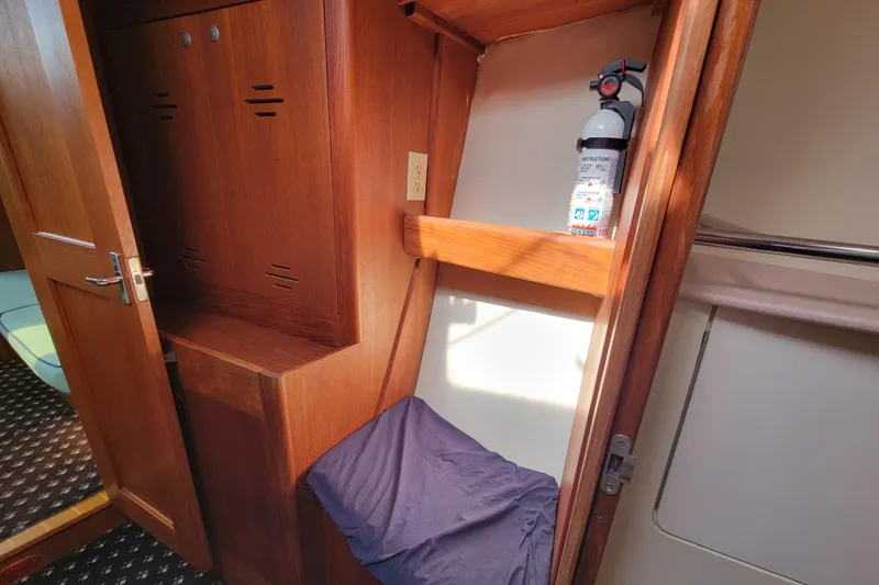 Slide: The Image of Interior of 2001 Hunter Passage 420 sailboat with wooden cabinetry and fire extinguisher. - 32