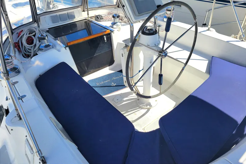 Slide: The Image of Cockpit of 2001 Hunter Passage 420 sailboat with steering wheel and blue seating. - 9