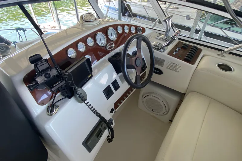 Slide: The Image of 2002 Silverton 330 Sport Bridge helm with gauges, steering wheel, and navigation equipment. - 10