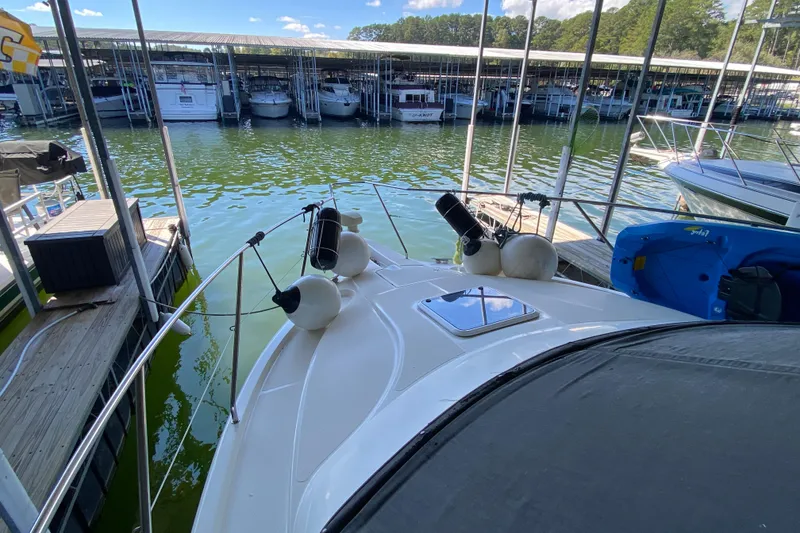 Slide: The Image of 2002 Silverton 330 Sport Bridge docked at marina, surrounded by calm water and boats. - 12