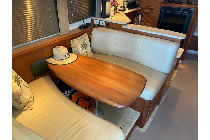 Slide: The Image of 2002 Silverton 330 Sport Bridge interior with cozy seating and wooden table. - 19