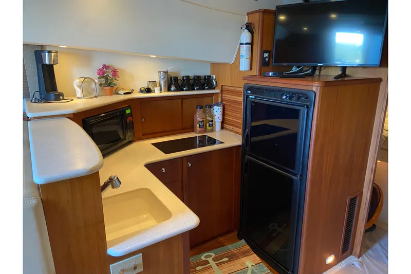 Slide: The Image of 2002 Silverton 330 Sport Bridge kitchen with appliances, sink, and TV. - 21