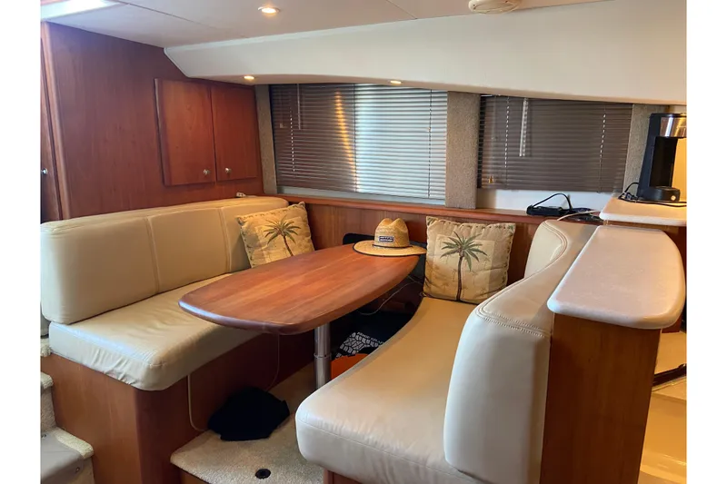 Slide: The Image of Interior of 2002 Silverton 330 Sport Bridge with cozy seating and wooden table. - 22