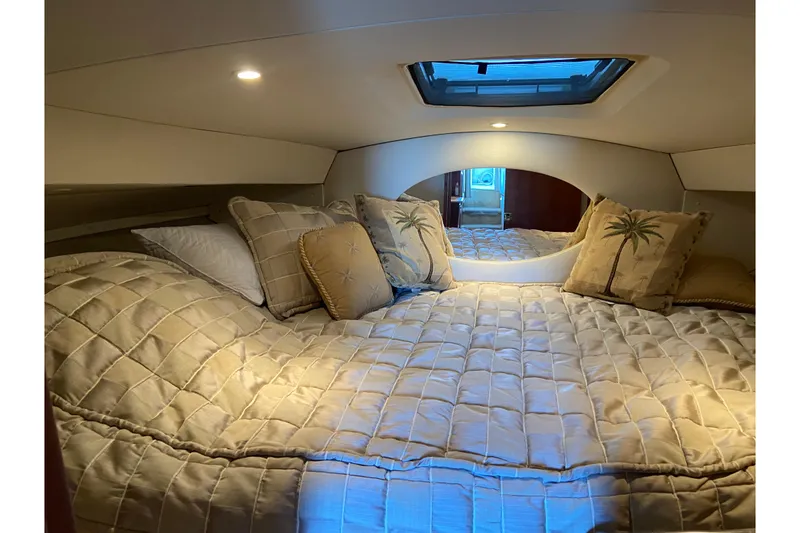 Slide: The Image of Cozy cabin interior of 2002 Silverton 330 Sport Bridge with plush bedding and decorative pillows. - 23