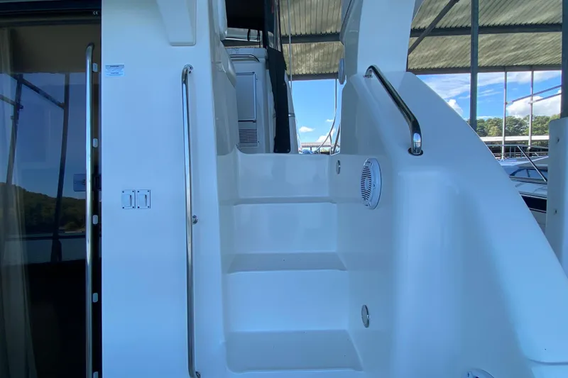 Slide: The Image of Staircase on 2002 Silverton 330 Sport Bridge yacht, featuring sleek white design and metal railings. - 5