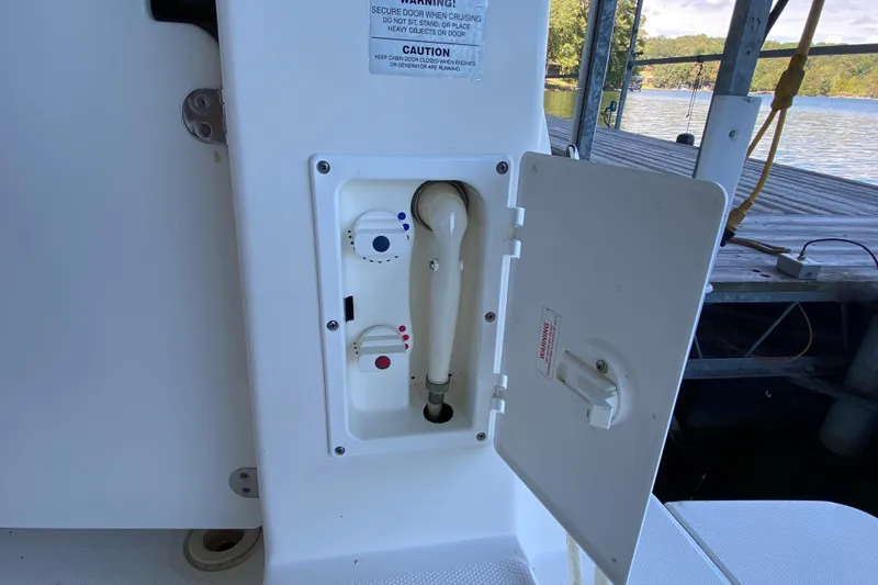 Slide: The Image of 2002 Silverton 330 Sport Bridge boat water hookup compartment with open access panel. - 6