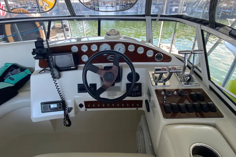 Slide: The Image of 2002 Silverton 330 Sport Bridge helm with steering wheel, gauges, and controls. - 8