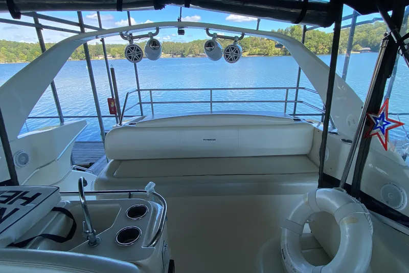 Slide: The Image of 2002 Silverton 330 Sport Bridge yacht interior with lake view, featuring seating and speakers. - 9