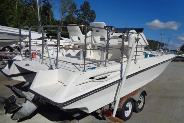 Slide: The Image of 1990 Wellcraft 24 Coastal Walkaround boat on trailer, parked outdoors. - 4