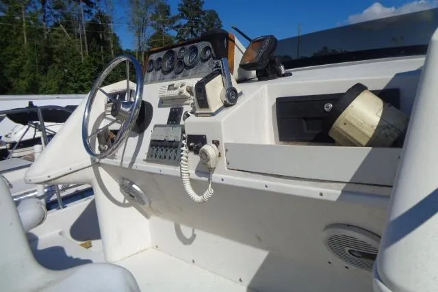 Slide: The Image of 1990 Wellcraft 24 Coastal Walkaround boat dashboard with steering wheel and navigation instruments. - 6