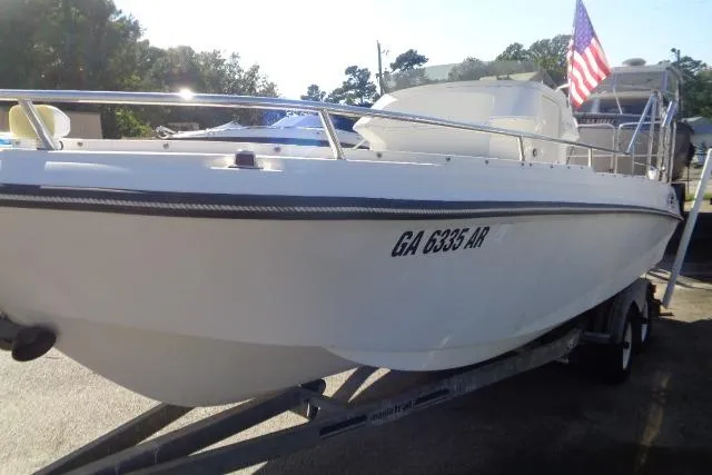 Slide: The Image of 1990 Wellcraft 24 Coastal Walkaround boat on trailer with American flag. - 9