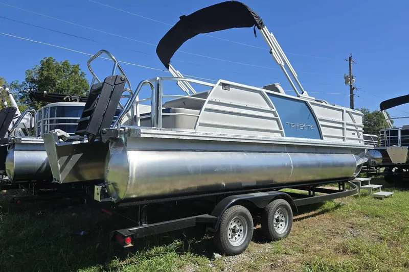 Slide: The Image of 2026 Trifecta 25LE pontoon boat on trailer, featuring sleek design and modern amenities. - 2