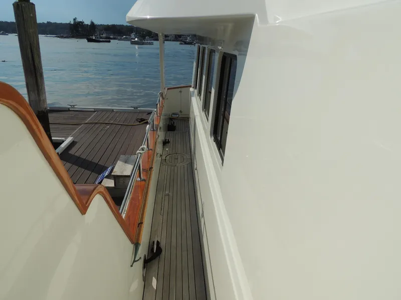 Slide: The Image of Side deck view of 1999 Lyman-Morse pilothouse yacht docked by the water. - 11