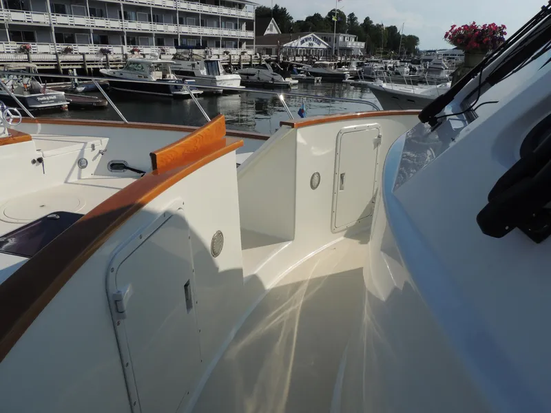 Slide: The Image of 1999 Lyman-Morse pilothouse yacht docked at marina, featuring sleek design and wooden accents. - 14