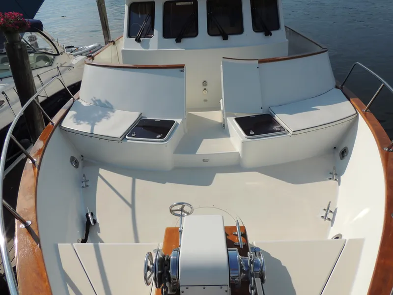 Slide: The Image of 1999 Lyman-Morse pilothouse boat with spacious deck and seating, docked by the water. - 18
