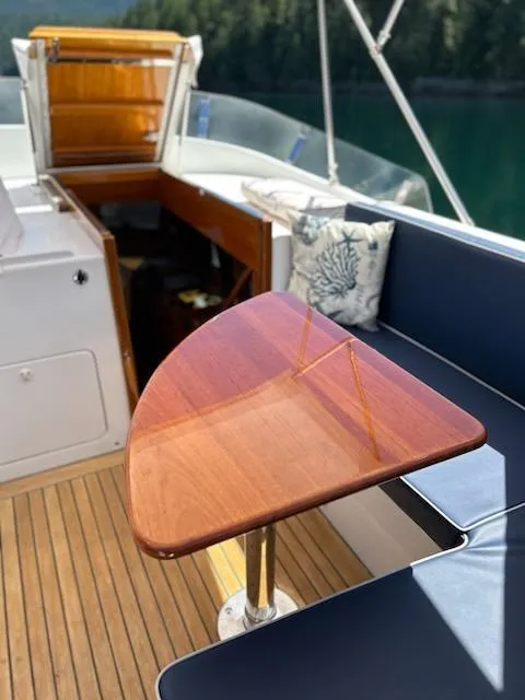 Slide: The Image of 1999 Lyman-Morse pilothouse interior with wooden table and blue seating. - 21