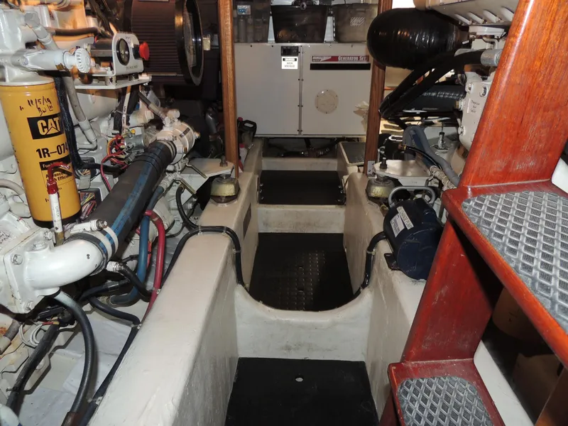 Slide: The Image of Engine room of a 1999 Lyman-Morse pilothouse boat, featuring mechanical components and equipment. - 23