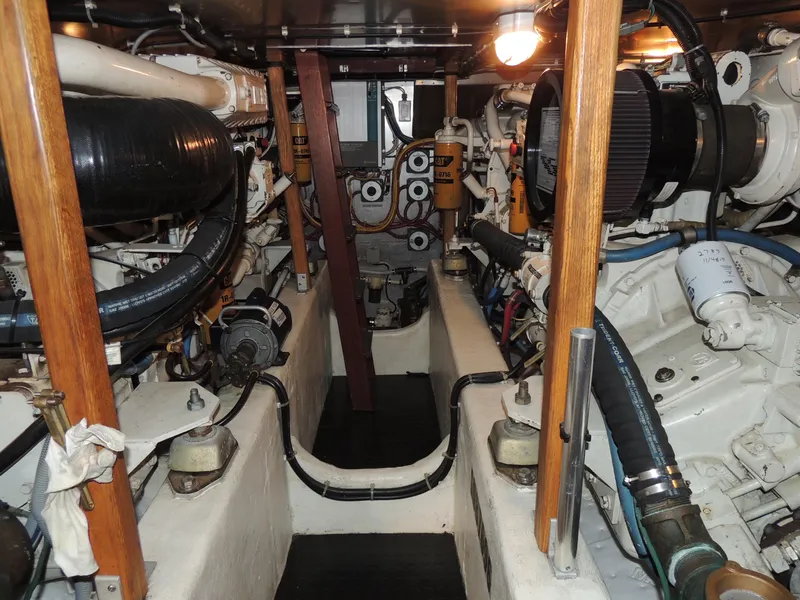 Slide: The Image of Engine room of a 1999 Lyman-Morse pilothouse yacht, showcasing mechanical components and piping. - 24
