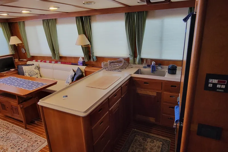 Slide: The Image of Luxurious 1999 Lyman-Morse pilothouse interior with elegant wood finishes and cozy seating area. - 28