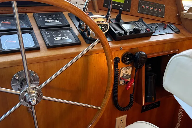 Slide: The Image of 1999 Lyman-Morse pilothouse helm with wooden wheel and navigation instruments. - 44