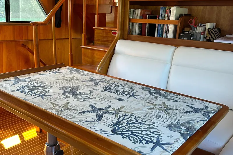 Slide: The Image of 1999 Lyman-Morse pilothouse interior with nautical-themed table and white seating. - 45
