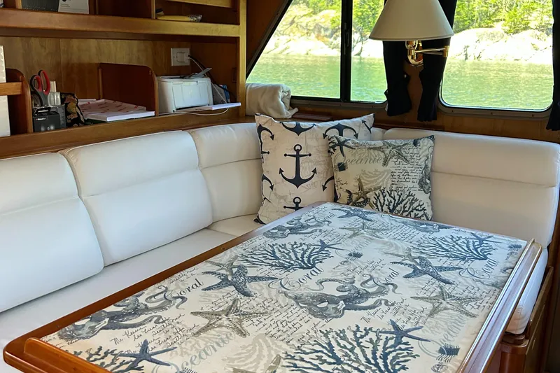 Slide: The Image of Cozy 1999 Lyman-Morse pilothouse interior with nautical-themed decor and scenic window view. - 46