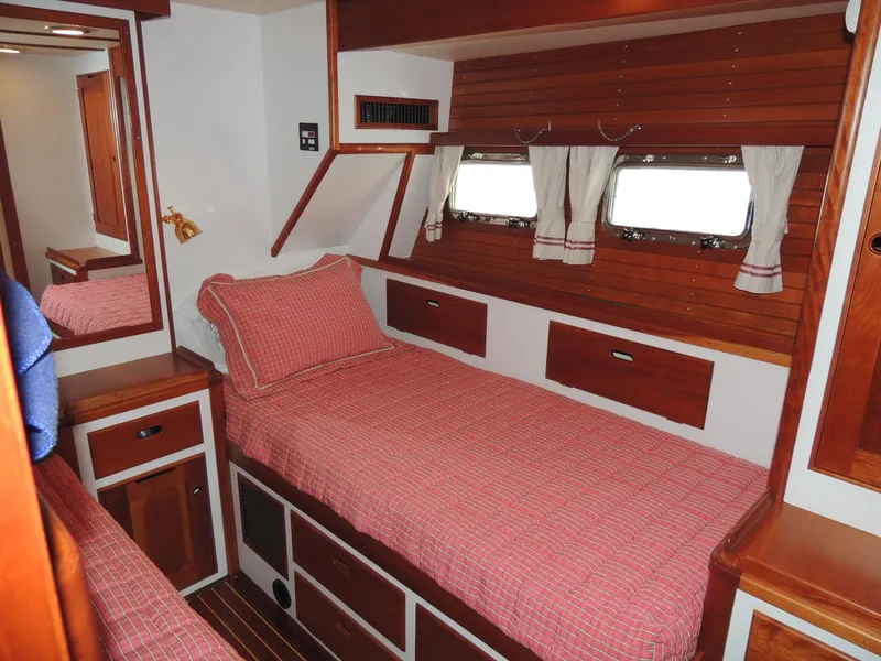 Slide: The Image of 1999 Lyman-Morse pilothouse cabin with wooden interior and red checkered bedding. - 48