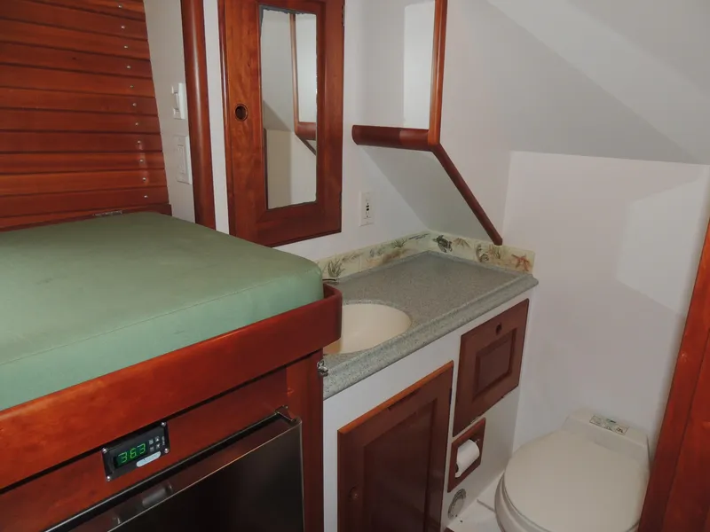 Slide: The Image of Compact bathroom in a 1999 Lyman-Morse pilothouse, featuring wood accents and modern amenities. - 53