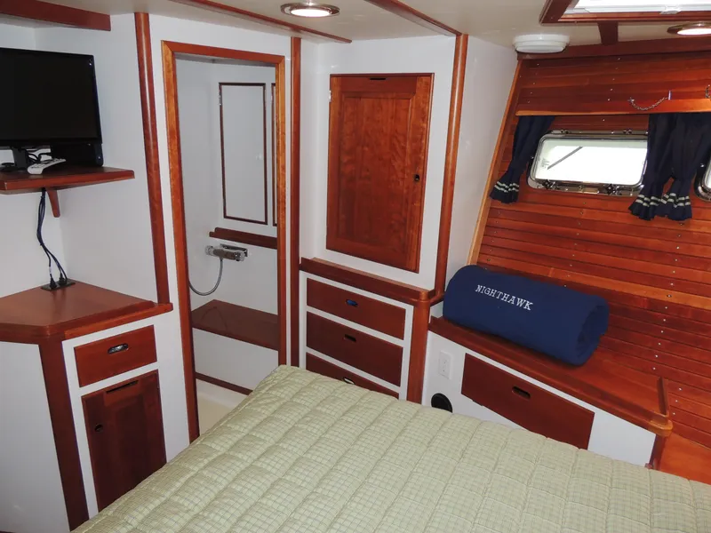 Slide: The Image of 1999 Lyman-Morse pilothouse interior with wood paneling, bed, and small TV. - 58