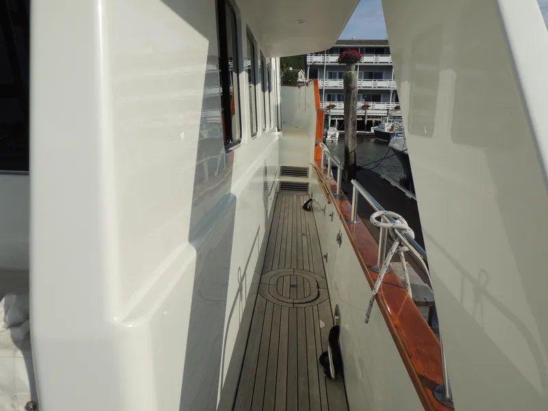 Slide: The Image of 1999 Lyman-Morse pilothouse yacht deck with wooden flooring and dock view. - 9