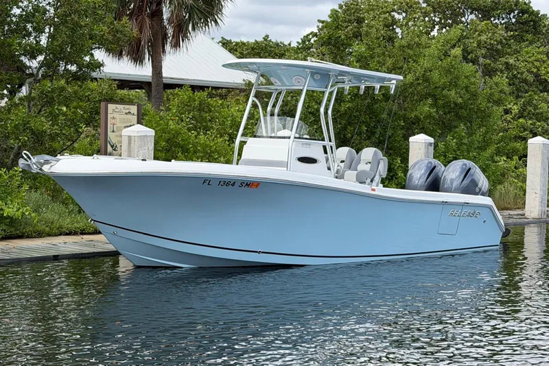 The Image of 2019 Release 240 RX boat docked on calm water, featuring dual engines and sleek design. - 0
