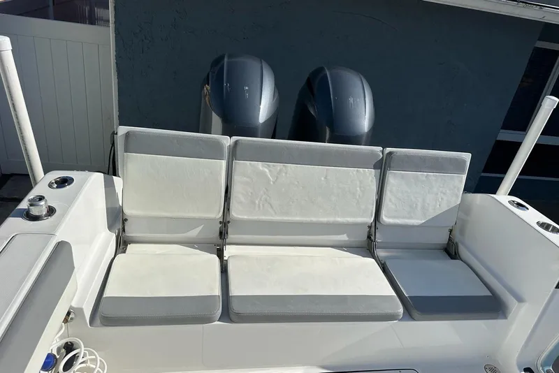 Slide: The Image of White seating area on a 2019 Release 240 RX boat, featuring dual engines. - 11