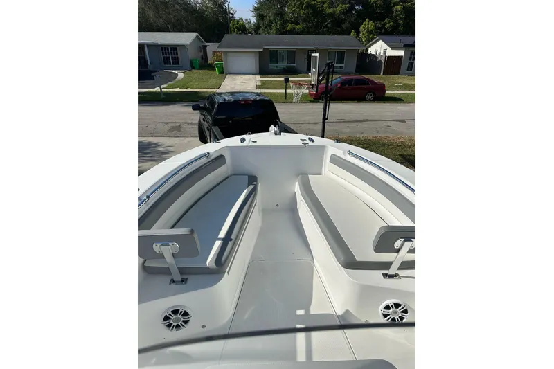 Slide: The Image of 2019 Release 240 RX boat with spacious seating, parked in a residential area. - 16