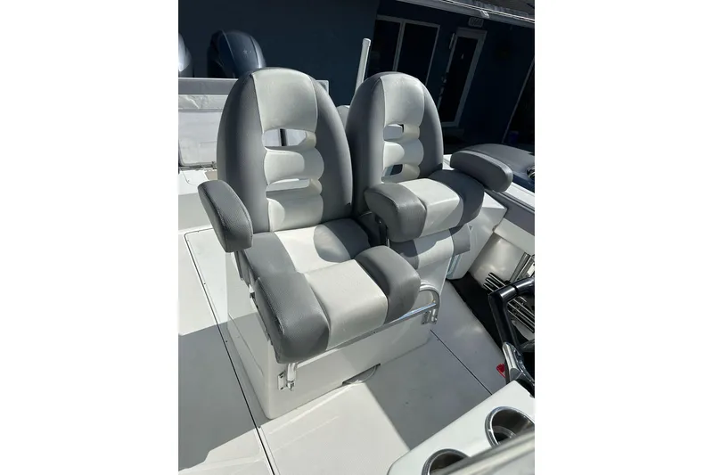 Slide: The Image of 2019 Release 240 RX boat seats, gray and white, with armrests and cup holders. - 17