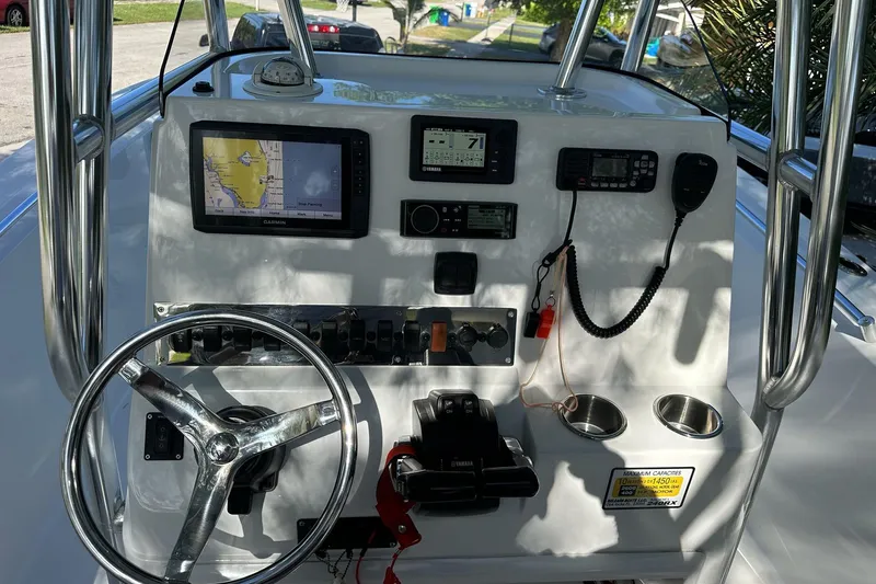 Slide: The Image of Boat dashboard with steering wheel, navigation screens, and controls, Release 240 RX, 2019 model. - 6