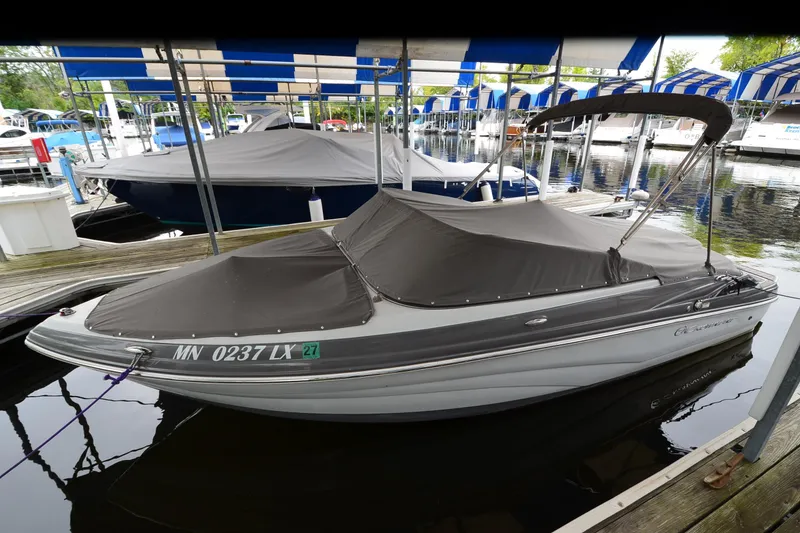 The Image of 2018 Crownline 205 SS boat docked with cover, in marina setting. - 1