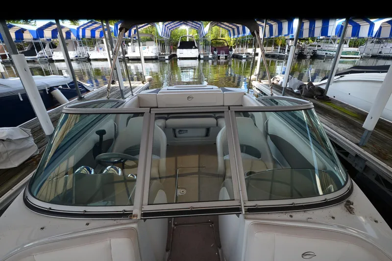 Slide: The Image of 2018 Crownline 205 SS boat docked in marina, featuring spacious seating and sleek design. - 10