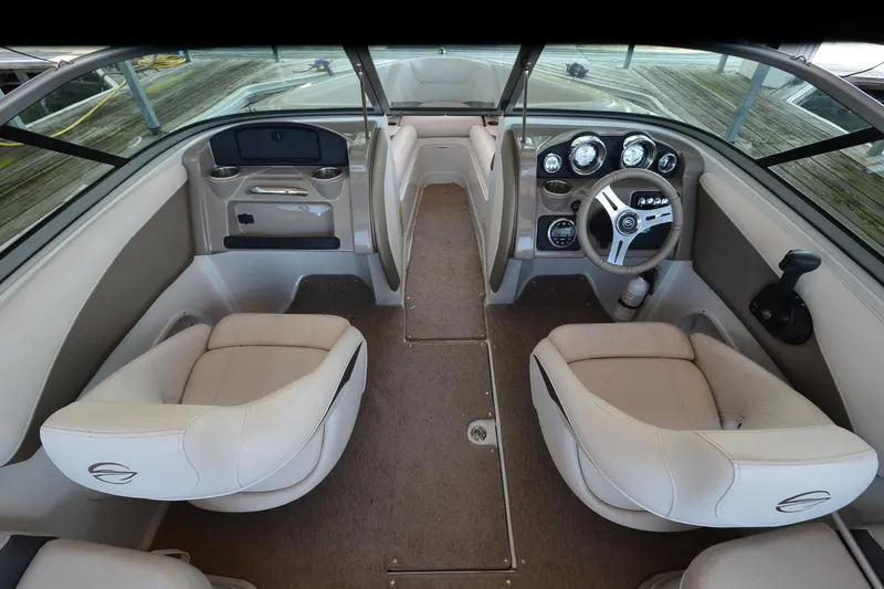 Slide: The Image of 2018 Crownline 205 SS boat interior with beige seating and modern dashboard. - 13