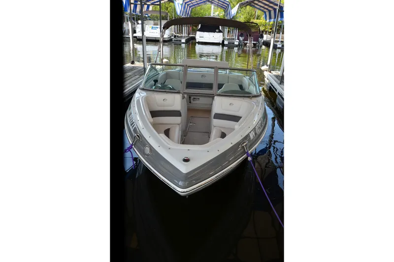 Slide: The Image of 2018 Crownline 205 SS boat docked in marina, featuring sleek design and spacious seating. - 16