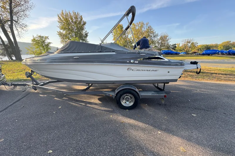 Slide: The Image of 2018 Crownline 205 SS boat on trailer, parked outdoors with scenic background. - 30